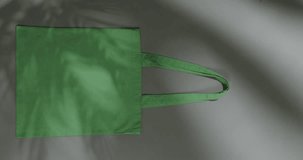 Vertical video of high angle view of green canvas bags with copy space on white background. Bags, fashion and accessory.
