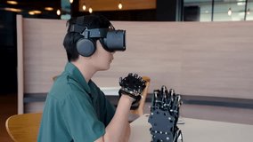 4K, Asian boy wearing 3D ride on head covers eyes, look at be realistic visual player, have hand tools and hand-operated robot It is technology for helping people with disabilities.