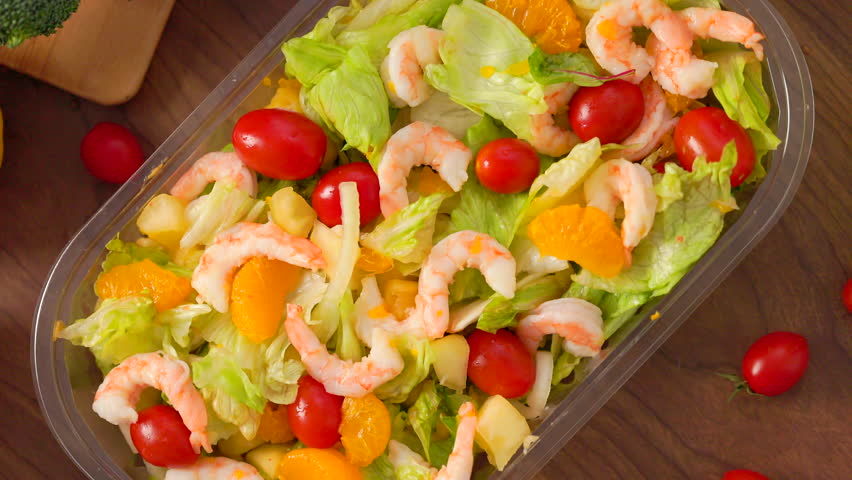 Top view the salad with tomatoes, shrimp and vegetables.