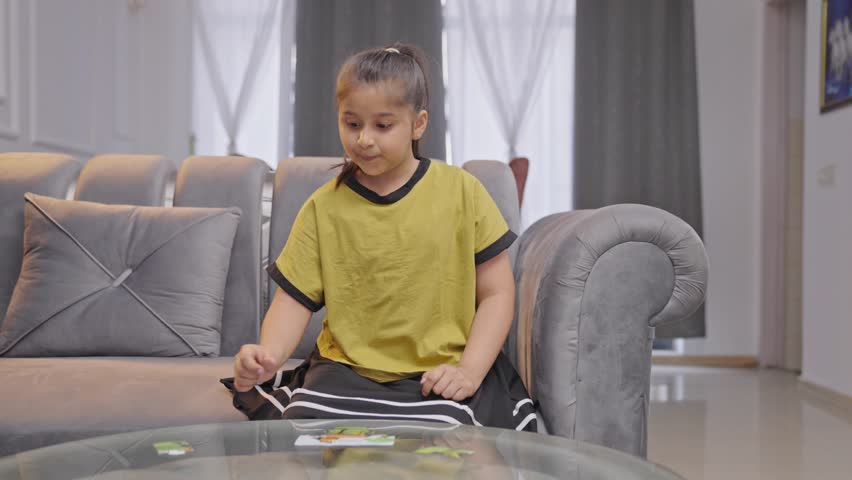 Happy Indian girl kid completes a jigsaw puzzle