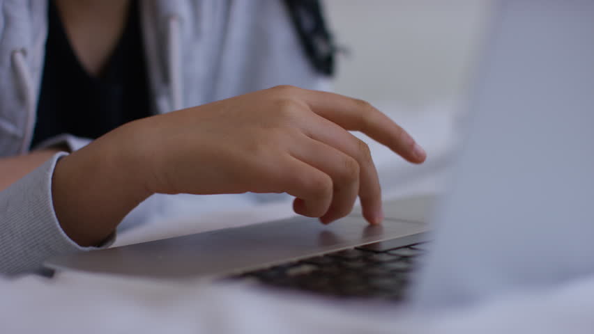 Young girl scrolling on her trackpad of her laptop computer  Royalty-Free Stock Footage #1102368493
