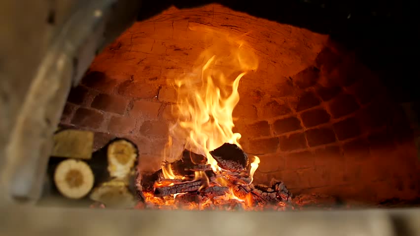 Beautiful high flames of fire from burning firewood in a traditional stone oven in a bakery. Fire burns in a professional brick oven in slow motion. Restaurant or pizzeria bake in the oven Royalty-Free Stock Footage #1102371223