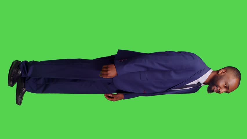 Vertical video: Profile of male employee in suit doing sign to come over, posing over isolated full body green screen backdrop. Startup worker calling people over, asking to join or accompany on