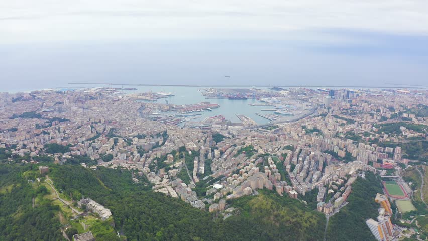 Inscription on video. Genoa, Italy. Central part of the city, aerial view. Ships in the port. Blue lights form luminous. Electric style, Aerial View