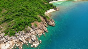 The beach is surrounded by lush greenery, with tall palm trees swaying in the breeze. The clear waters are home to a diverse range of marine life, making it a popular spot for snorkeling. Thailand
