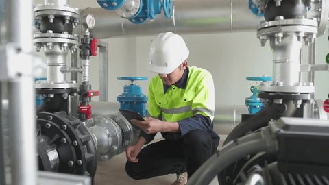 A engineering at inspects water pump valves equipment in a substation for the distribution of clean water at a large industrial estate. Water pipes. Industrial plumbing. Slow motion Shot. : vidéo de stock