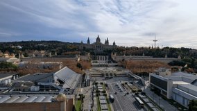 Aerial long view of Avinguda de la Reina Maria Cristina at its junction with Montjuic Palace in background. This iconic square is located at foot of Montjuic major landmark in Barcelona. 4K video.
