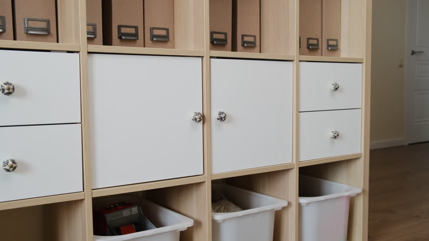 Toddler baby plays with household chemicals and detergent bottle from the closet. Child boy with cleaners products in home living room. Kid about two years old (age one year nine months)