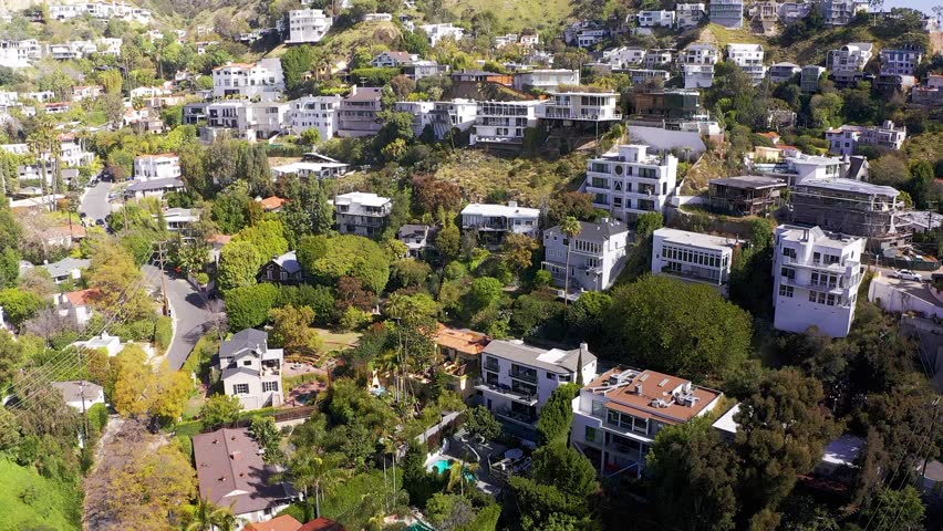 Wide reverse pullback aerial shot of homes on the hills above the Sunset Strip in Beverly Hills, California. HD at 60 FPS