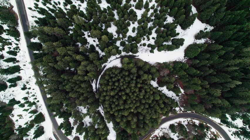 Overhead view of Swiss alp roads in winter foggy day. Drone passing through clouds. Sattelegg, Switzerland