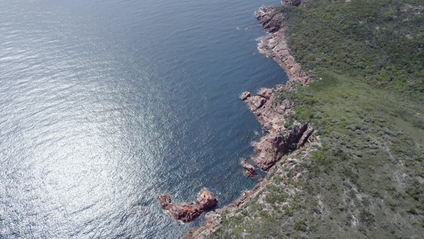 Sunlit Waters Of Wineglass Bay And Rocky Coastline Of Freycinet National Park In Summer In Tasmania, Australia. - aerial