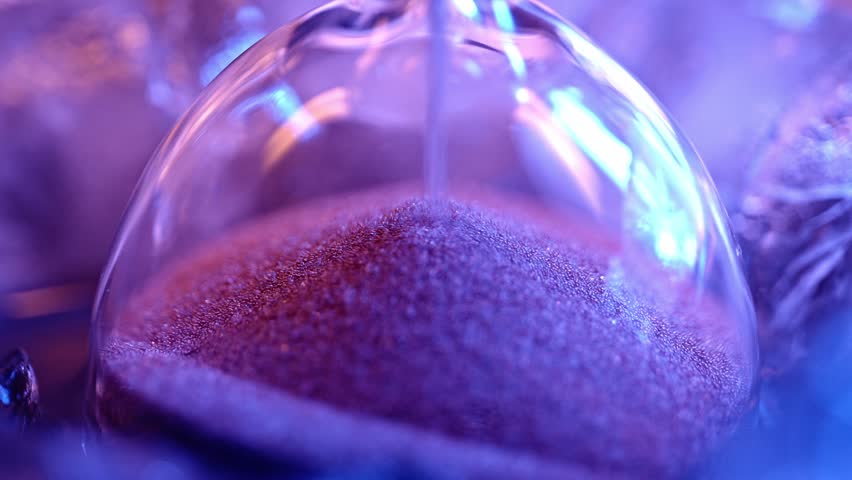 Hourglass on blue background with falling sand