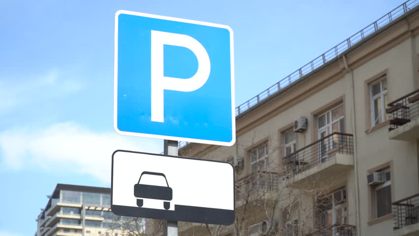 Road sign P indicating parking with buildings in the background