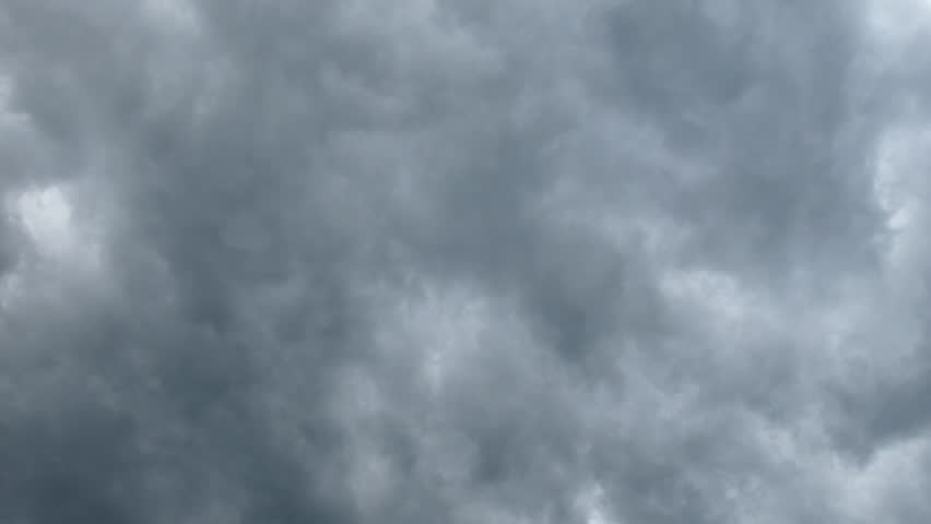 Airplane appears tiny as it passes before dark, stormy clouds (zoom-in applied) - Canterbury, New Zealand