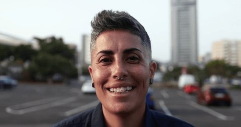 Gay woman smiling in front of camera with cityscape in the background Stock Video