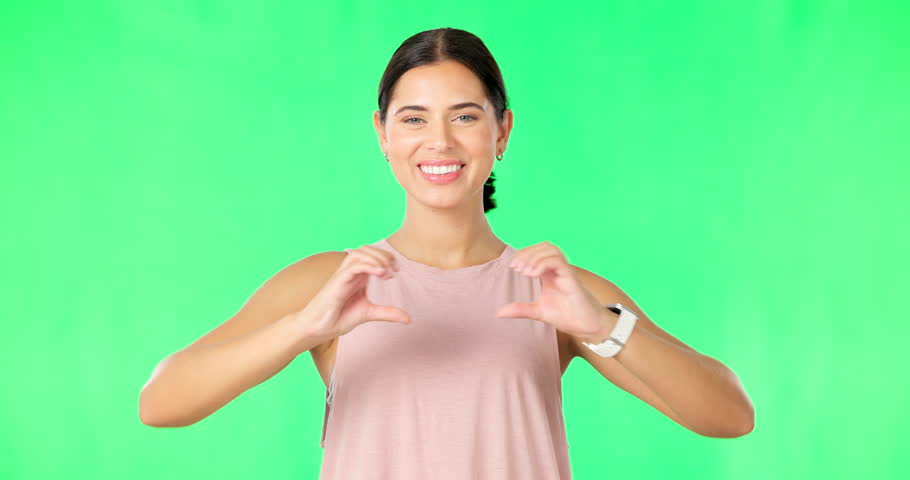 Heart, hands and face of happy woman on green screen for fitness, wellness or healthy life. Female portrait, sports model and finger shape of love, support and motivation for care, emoji sign or icon