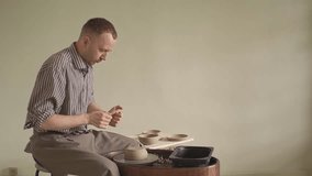 a man in a pottery workshop works on a potter's wheel. kneads pieces of clay. slow motion video. High quality Full HD video recording