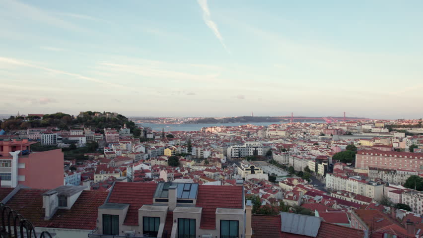 Panning aerial view of ancient coastal city Lisbon, Portugal cityscape, horizon and harbor