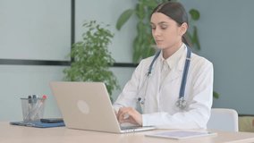 Online Video Chat by Young Female Doctor on Laptop in Clinic