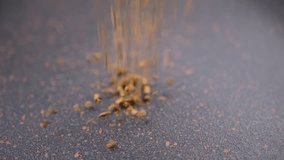 Instant Coffee Granules Fall and Scatter into a Heap on a Black Background. Slow motion. Close up. A stream of brown powder, gold particles, soluble coffee granules flies into a pile. Texture, light. - Powered by Shutterstock - Get 15% off with code: PIKWIZARD15