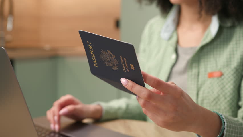 Hands Holding US Passport. Mixed Race woman typing holding US passport document. Close Up. Royalty-Free Stock Footage #1102409393
