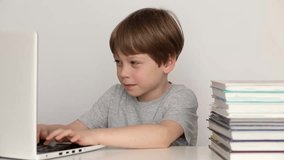 Boy sit at table studying at home online use laptop, Video call, homeschooling, modern tech concept