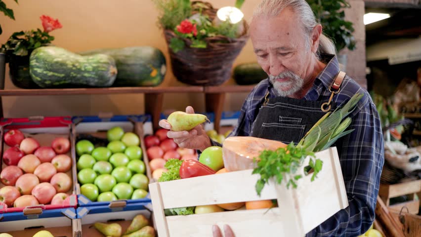Senior man selling fresh vegetables and fruits at organic local market store - Food retail and small business concept