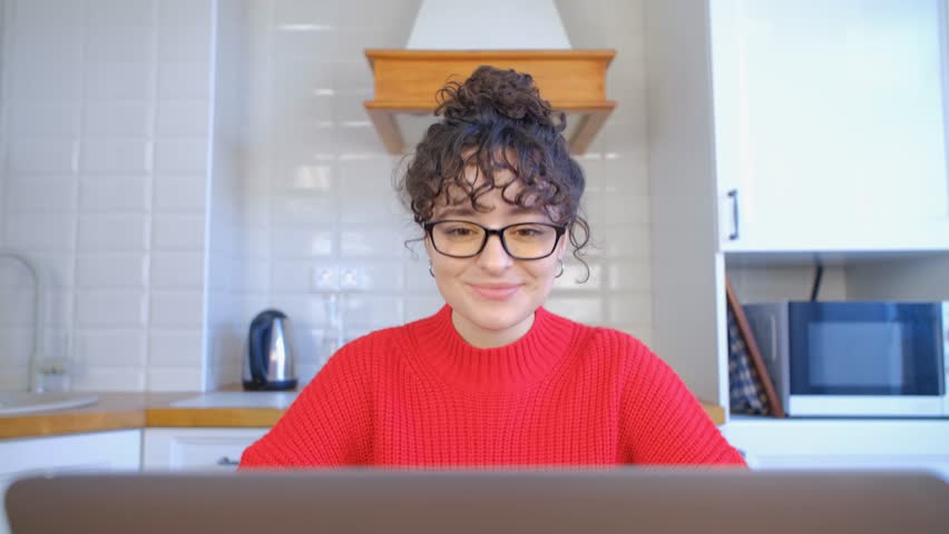 Friendly Ukrainian girl saying hello on a video call. Portrait of cheerful white female with brunette hair speaking on a web camera | Shutterstock HD Video #1102418473