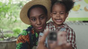 African young women and girl using a cell phone to take a selfie on a farm. Two femal enjoy the moment, expressing themselves through technology and capturing memories of their time on the farm.
