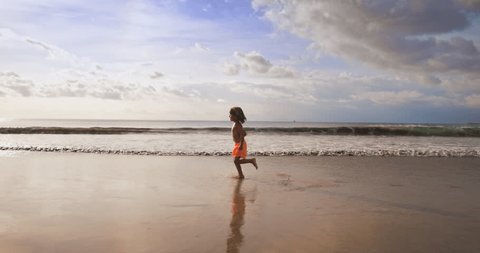 Стоковое видео: Slow motion of happy boy run on the beach with big waves on background