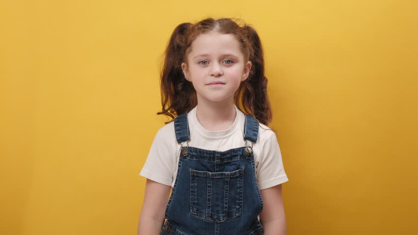 Portrait happy little girl stretching relaxing, smiling small child with eyes closed feel peaceful breathing fresh air, good pleasant smell, posing isolated on yellow color background wall in studio Royalty-Free Stock Footage #1102421905