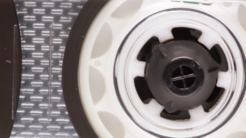 A close up to a take-up reel with little magnetic tape of an audio cassette. Royalty-Free Stock Footage #1102422643