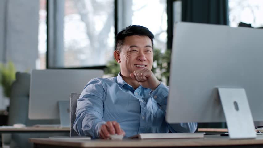 Successful occupation. Happy middle aged asian man web surfing online on pc and smiling, resting at office in end of week, tracking shot, slow motion, free space Royalty-Free Stock Footage #1102426247