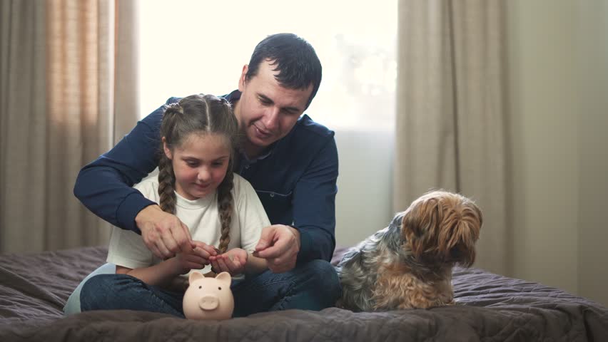 family path to financial security. valuable lessons in budgeting.dad teaches his child to save money.Father and daughter make investments using piggy bank.Saving family money.Father and child teamwork Royalty-Free Stock Footage #1102427727