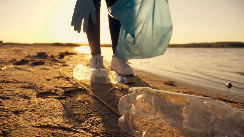People collect plastic trash on beach. Recycling plastic waste. Clean beach. family collects garbage on beach. Put plastic in trash bag.clean up day, collecting waste on beach Royalty-Free Stock Footage #1102427755