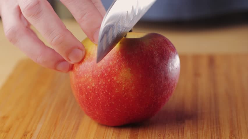 Chef cuts apples with knife on a cutting board to make dessert compote or fruit juice. Apple diet for a set of vitamins.
