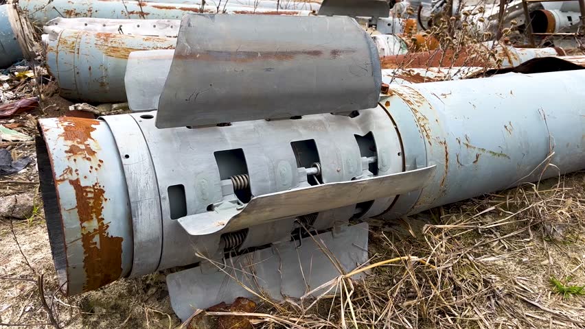The tail section of the rocket of the Uragan multiple rocket launcher system, lying on the ground in dry grass. The Russian-Ukrainian war. Shelling of peaceful Ukrainian cities