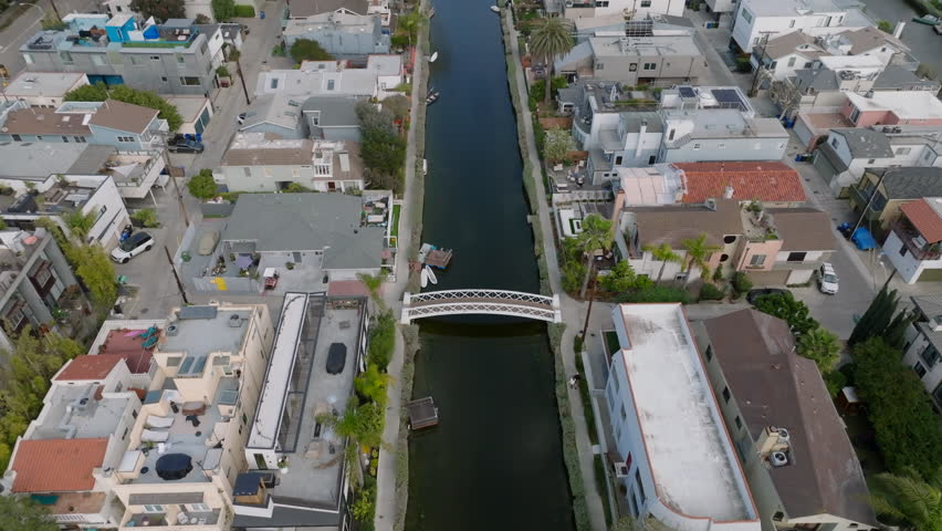 High angle view of water canal surrounded by family houses in city. Dense town development in Venice residential neighbourhood. Los Angeles, California, USA