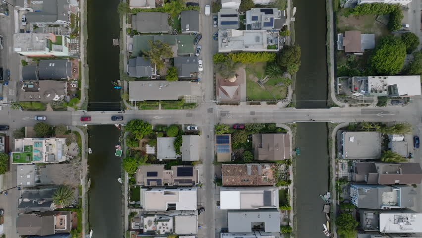 Top down panning footage of cars slowly moving on street in residential urban borough with water canals. Los Angeles, California, USA