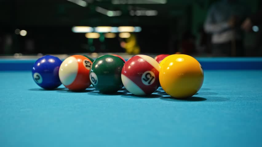 Opening Break Shot of Eight Ball Pool Game Spreading Balls Around Blue Fabric Table Surface