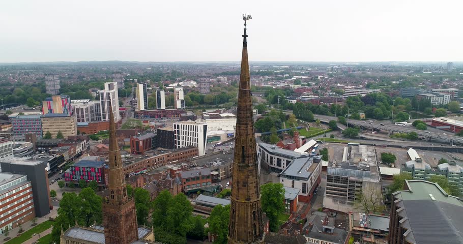 Aerila based lowering crane shot of the old Coventry City Cathedral spire