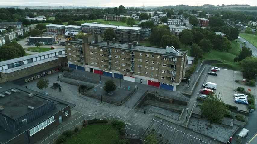 Drone shot of council estate housing block, shops and new developments behing in Letchworth Garden City