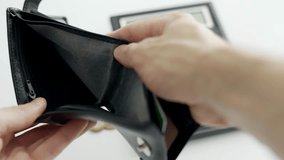 A man hands are opening an empty black wallet on background of calculator and coins. No money on payments. Running into debt. Concept of unemployment financial crisis or bankruptcy and poverty. - Powered by Shutterstock - Get 15% off with code: PIKWIZARD15