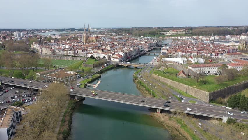 France, Basque country, Bayonne city. Drone aerial view above the Nive river and the Andre Grimard, Genie, Pannecau and Marengo bridges. Sainte-Marie cathedral in back and rugby stadium on the left.