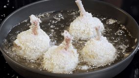  Food preparation. Fried chicken in frying pan in boiling Oil. Unhealthy food. Close up shot. Frying delicious fried chicken at home. Selective focus. Slow motion video