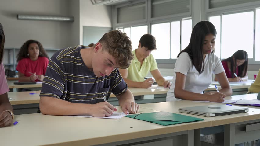 College Student writing notes in a Classroom. Diverse Group of Multiracial teenagers Study at High School  Royalty-Free Stock Footage #1102450897