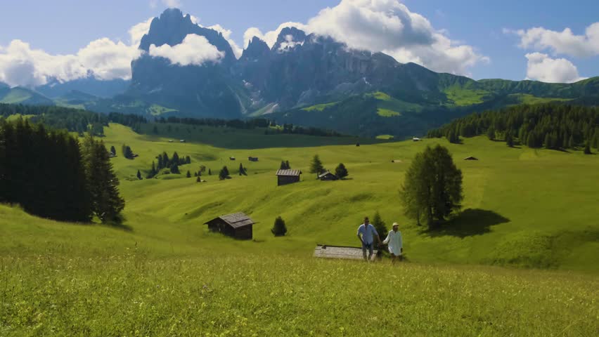 Alpe di Siusi mountain with Seiser Alm Sassolungo Langkofel mountain group in the background at sunset. a couple of men and women watching sunset in the mountains of the Dolomites Italy
