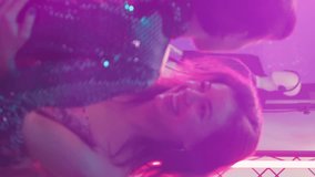 Vertical video: People dancing in pairs on slow music, enjoying romantic waltz on dance floor. Happy couples dancing waltz at modern discotheque, having fun together at party event. Handheld shot.