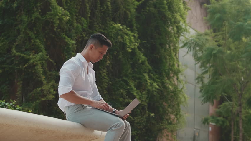 Young businessman using laptop while sitting next to business center
