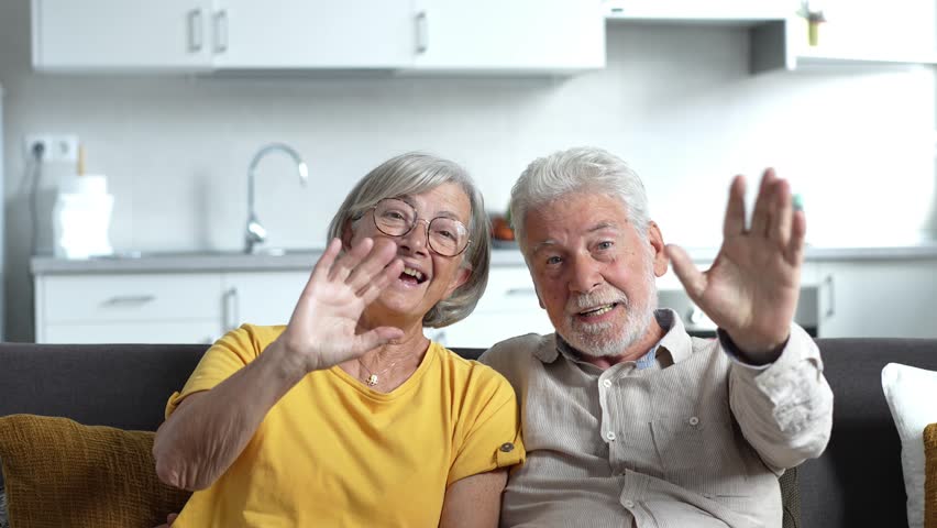 Sixty years couple, elderly parents communicates with grown up children using modern technologies makes video call, wave hands gesture of hello or goodbye sign, older generation and internet concept
 Royalty-Free Stock Footage #1102462119